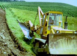 Raupe beim tiefen Wenden des Bodens mit dem Rigolpflug
